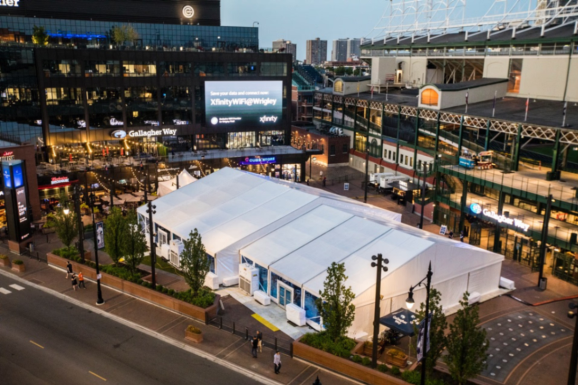 Aerial view of a large white event tent set up on the Gallagher Way plaza at Wrigley Field for a private event